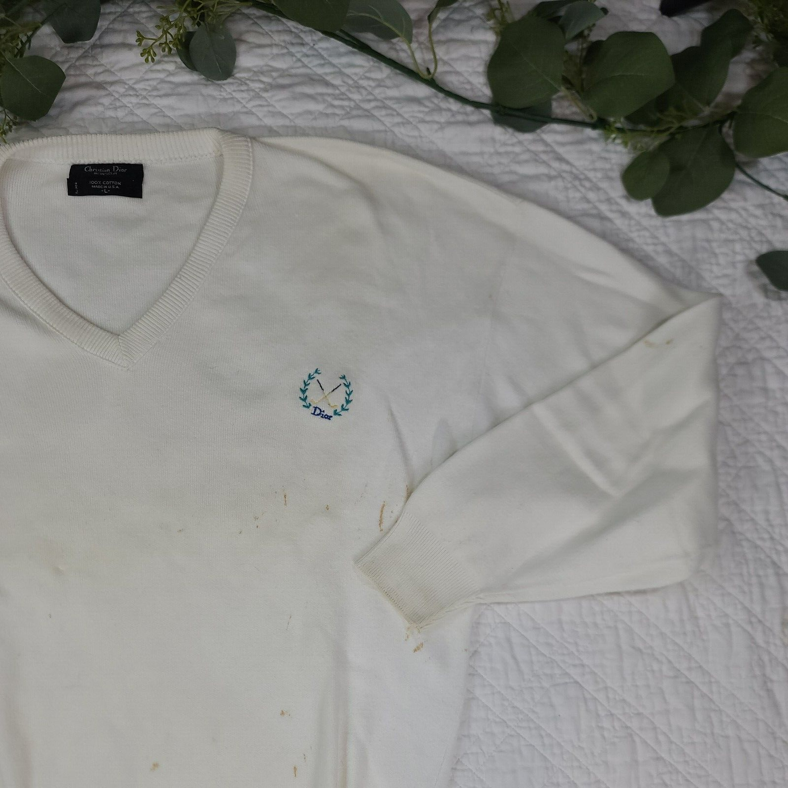 White V-neck Christian Dior men’s sweater with small green embroidered logo and stars on chest, made in USA.
