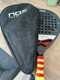 NOX AT10 Genius 12k 2025 Padel Racket with head cover.