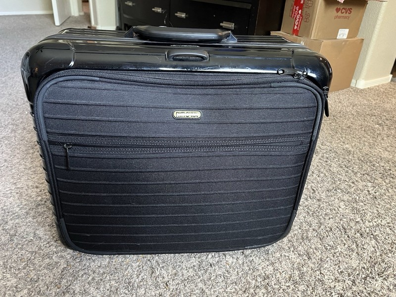 RIMOWA Business Trolley in black polycarbonate with front organizer compartment.