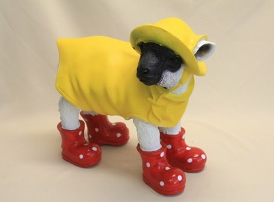 EINE LAMM TIERFIGUR AUS KUNSTSTEIN MIT FRIESENNERZ UND ROTEN STIEFELN