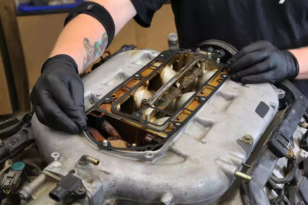 A mechanic installs the new intake manifold gasket.
