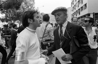 Jackie Stewart who was sidelined with a broken wrist talks with Lo- Old Photo