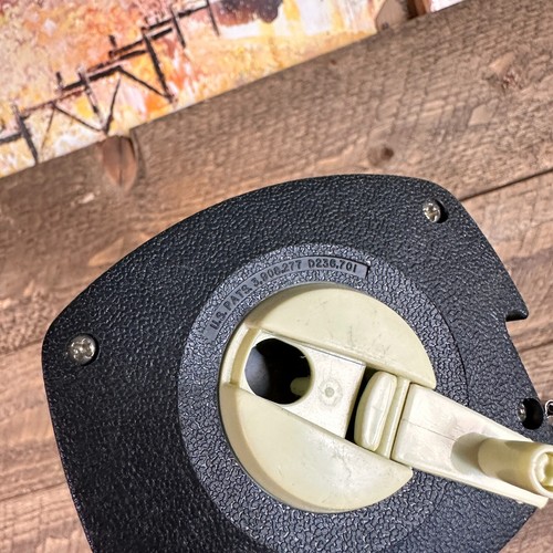Black vintage Stanley 50 foot hand crank with brass jaw, white faceplate, and engraved brand name on textured grip.