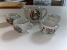 miniature porcelain tea set featuring afloral design and a courting couple scene