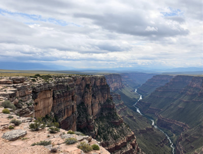 Vast Canyon with Distant Mountains and Cloudy Sky Poster Print