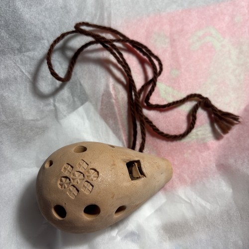 Hungarian clay ocarina known as a kortemuzsika with fingering chart