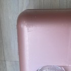 Pink rectangular Caboodle makeup box with visible scratches and textured edges against a white tile background.