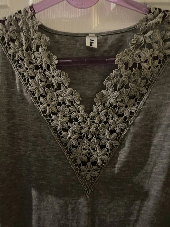 Top gris manga corta. Línea de cuello detallada floral. Inmaculada  Foto 2 de 3