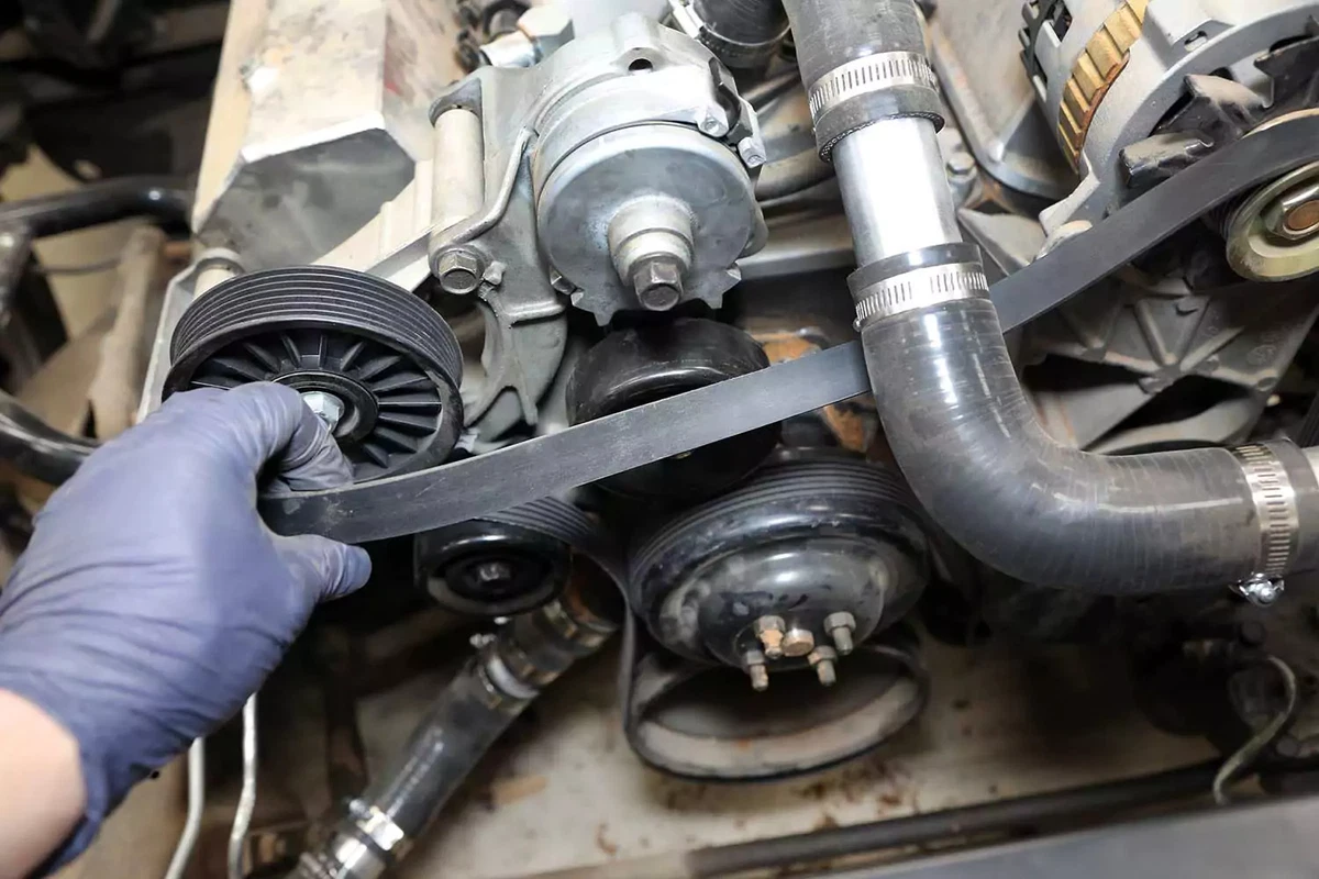 Reinstalling the ribbed drive belt.