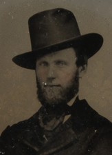 BEARDED MAN IN WESTERN HAT AND CROSSED ARMED POSE. TINTED 6TH PLATE AMBROTYPE.