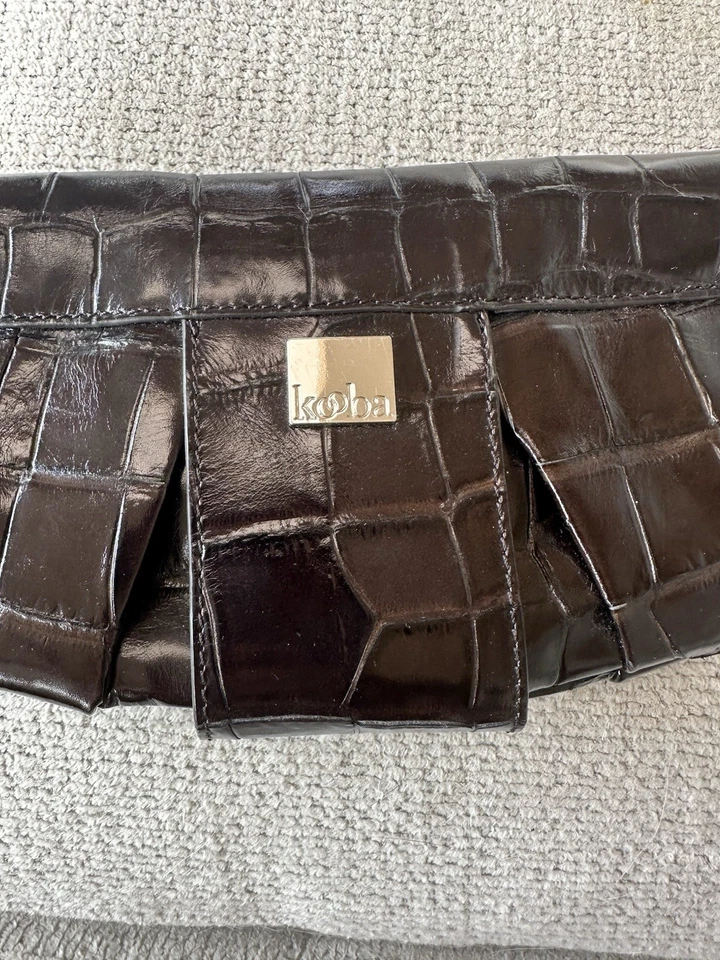 Bolso sin asas Kooba marrón oscuro de cuero en relieve de cocodrilo con detalles plateados Foto 3 de 4