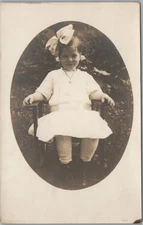 Baby Girl Oval Image Big Bow Necklace Sitting On Chair RPPC Postcard