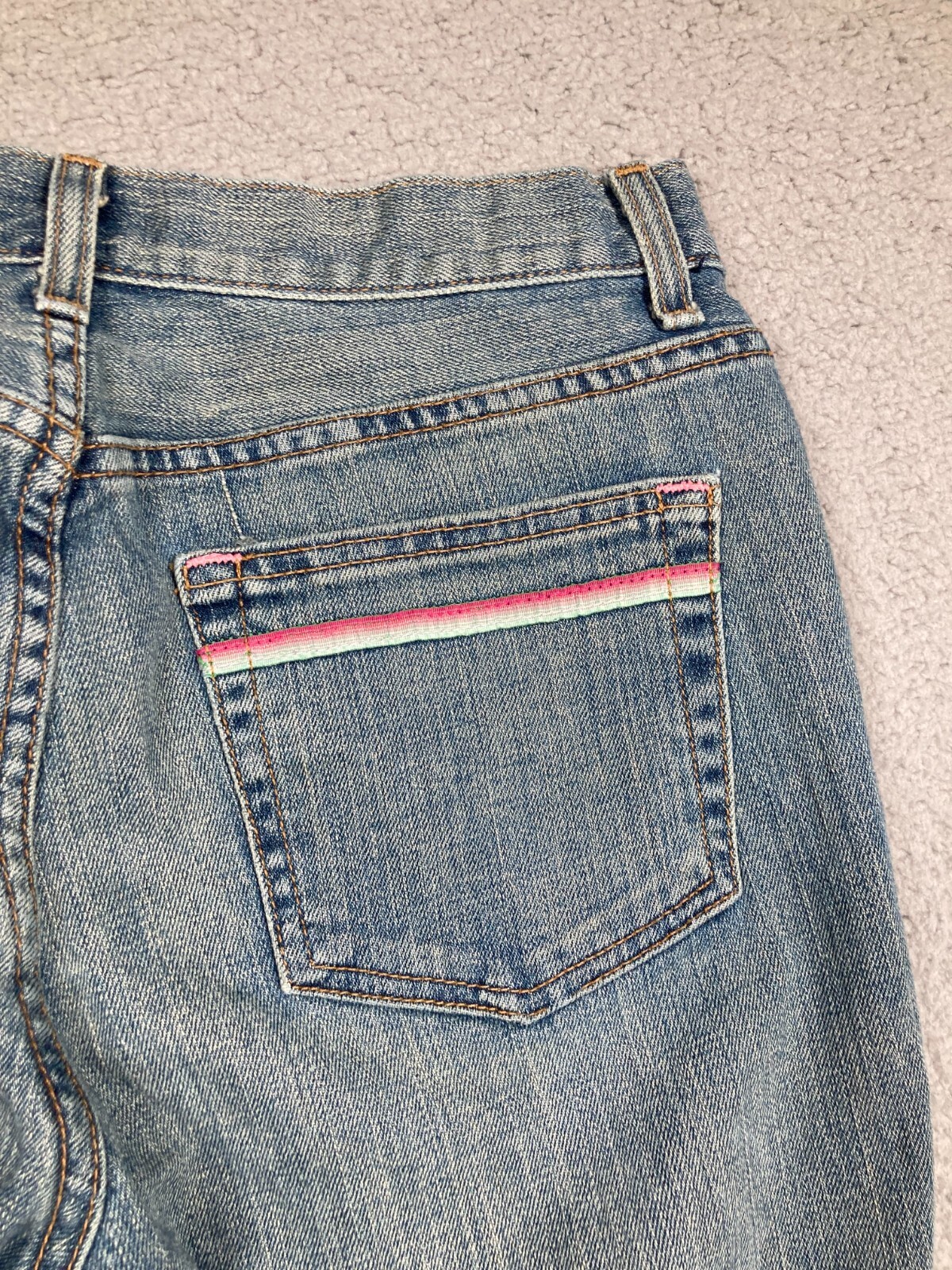 Blue Karen Kane Lifestyle jeans back pocket with pink and red stripe detail and “USA Made” text on waistband.