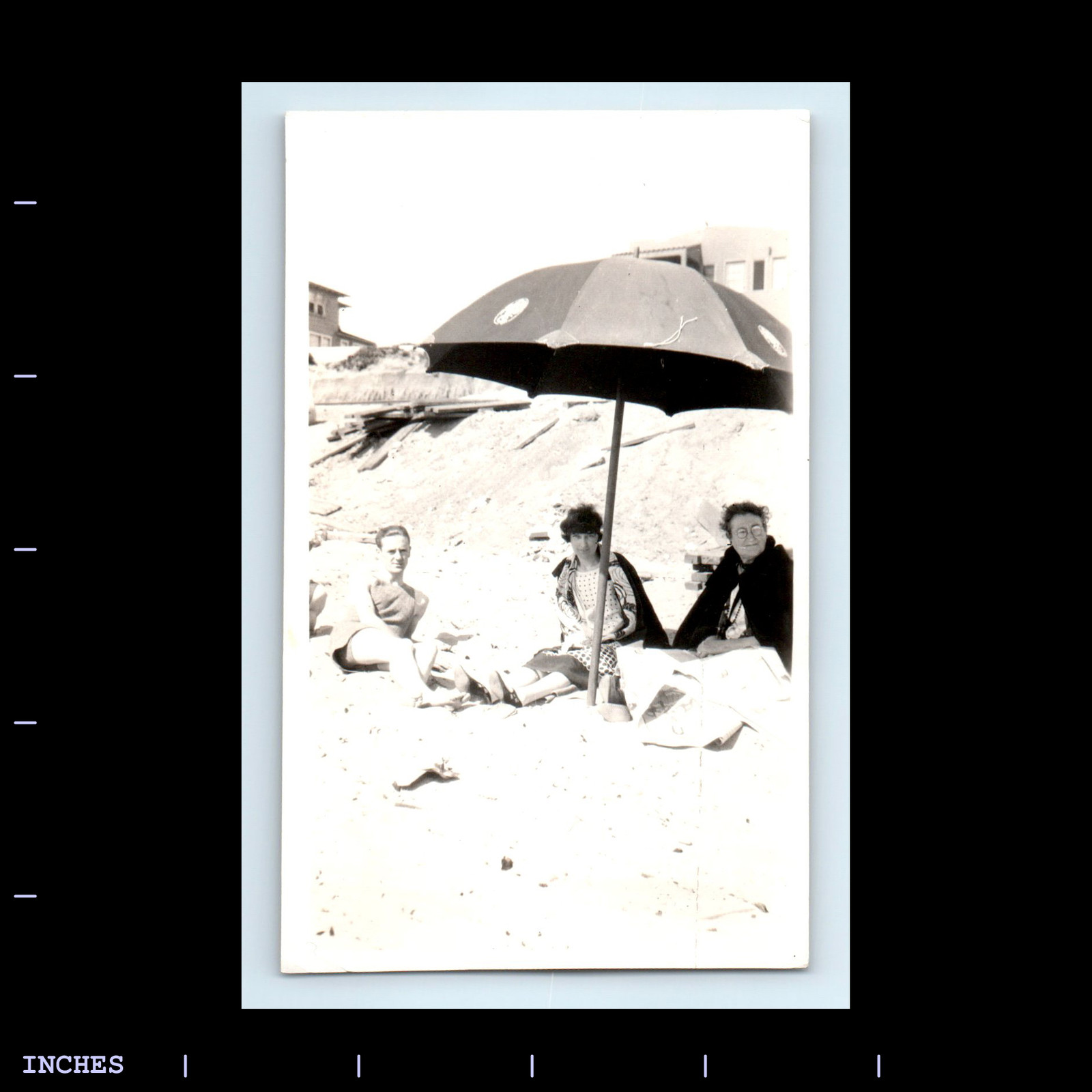 Vintage Beach Scene with Sunbathing Couple Under Umbrella