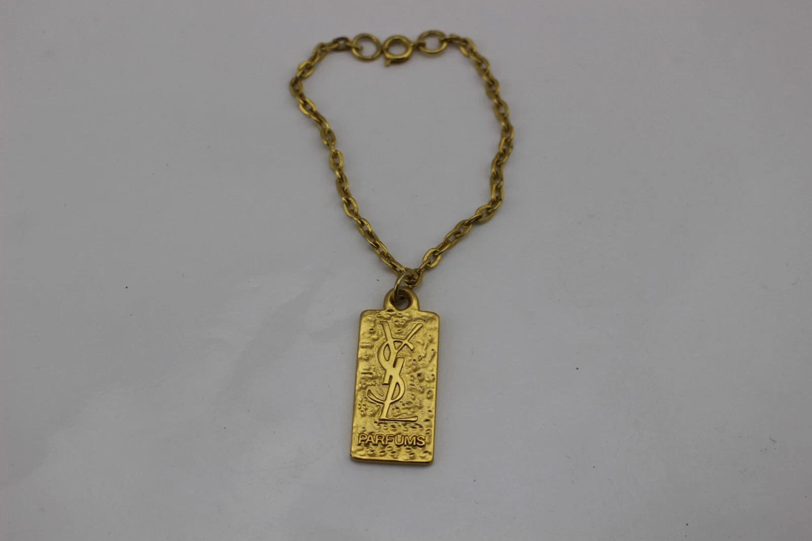 SAINT LAURENT (YSL) Bracciale Vintage YSL Parfums Yves St Laurent 7" Tono Oro con Charm Rettangolare