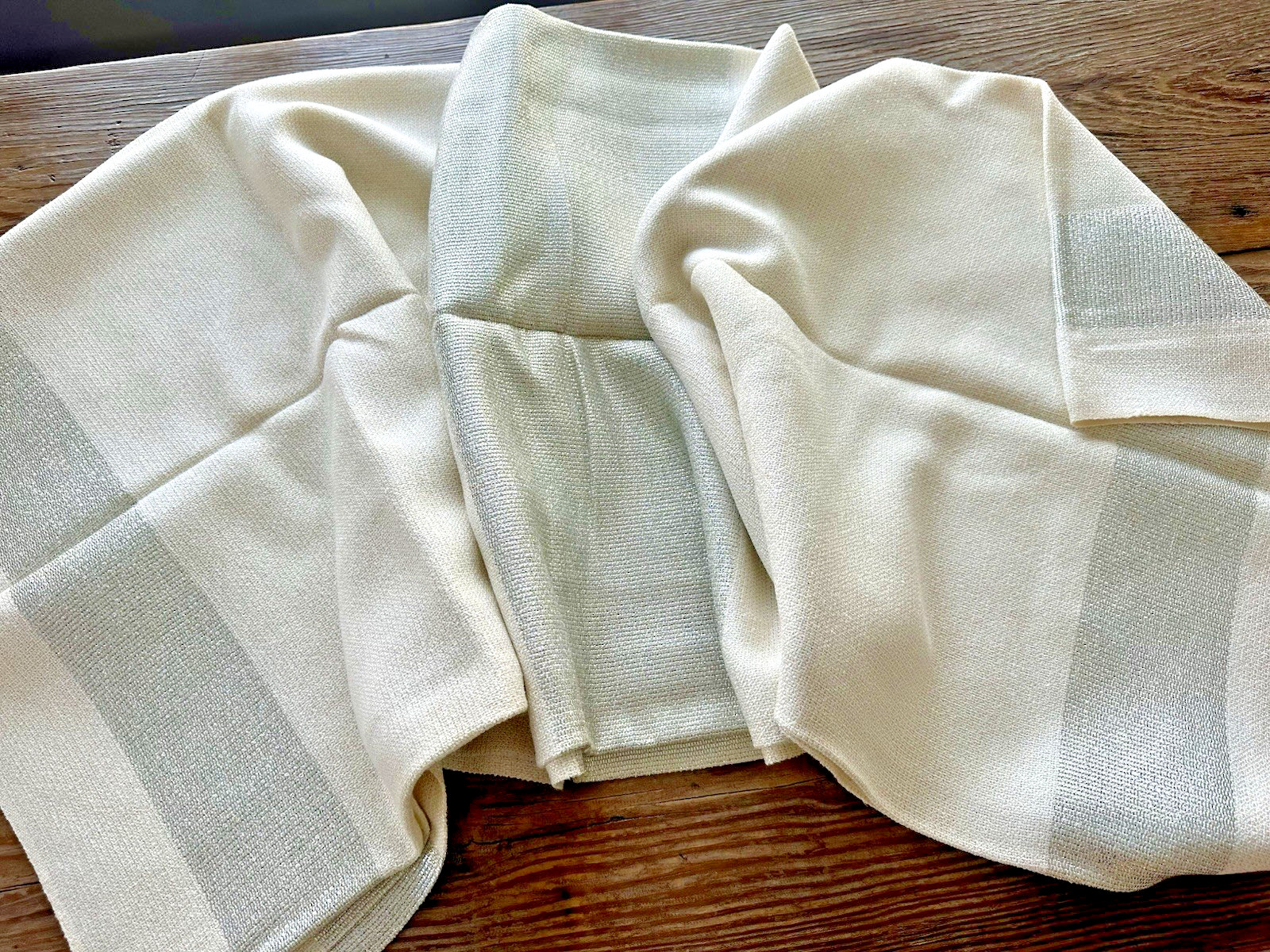 White tablecloth woven with metallic silver thread in a mid-century weave pattern.