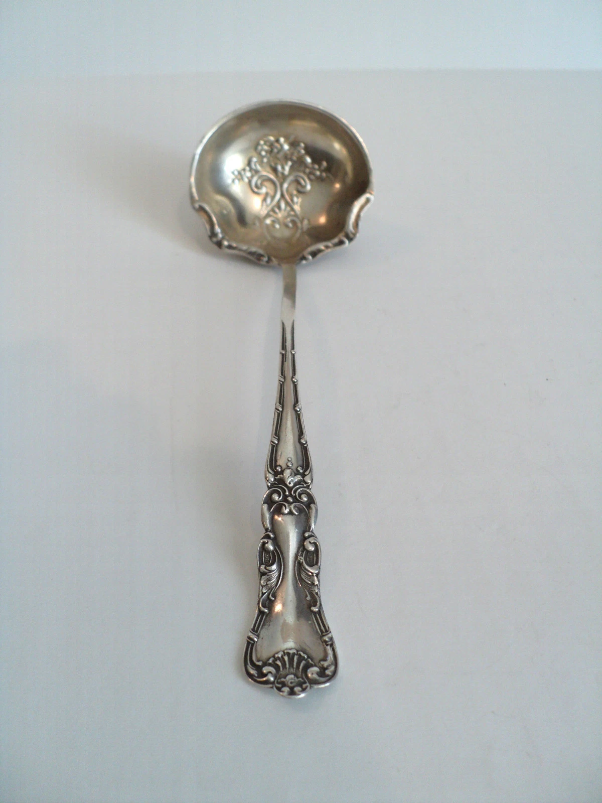 BAKER-MANCHESTER ANTIQUE STERLING SILVER SAUCE LADLE, EMBOSSED FLORAL DECORATION