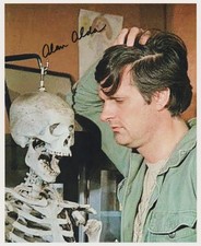 ALAN ALDA signed MASH color 8x10 w/ coa FUNNY CLOSEUP OF HAWKEYE WITH SKELETON