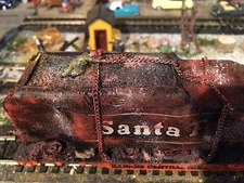 HO Tender Santa Fe on flat car heading to graveyard with worker.