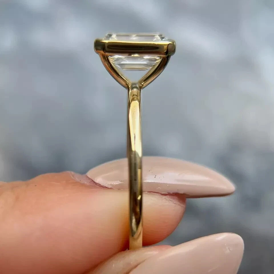 Conjunto de anillo de compromiso enchapado en oro amarillo de 14 K con bisel de moissanita corte esmeralda de 2,50 quilates Foto 2 de 4