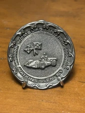 A coin commemorating Grand Prix at Watkins Glen, N.Y. reads "HOME OF GRAND PRIX"