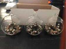 three open glass ornaments with wreath inside