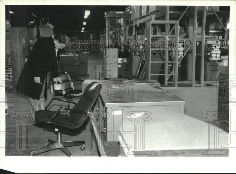 1995 Press Photo Man looks at office chairs for sale at Watervliet Arsenal, NY
