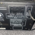 Back panel of Marantz TA 100 amplifier with switched and unswitched inputs, caution labels, and white printed specifications.