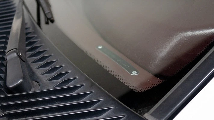A VIN vehicle identification number tag on the dash of a car as seen though the front windshield