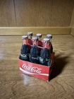 vintage miniature Coca-Cola six-pack featuring glass bottles cardboard carrier