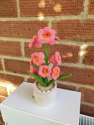 Süßes gehäkeltes heißrosa Maiglöckchen Blumen im Häkeltopf