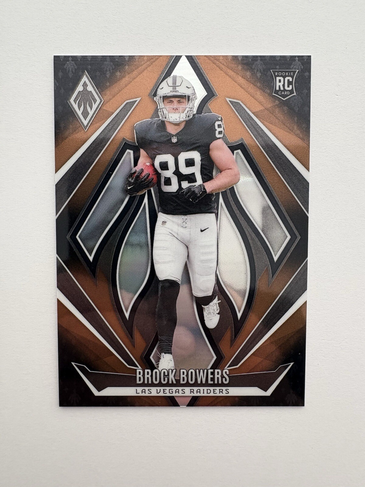 2024 Panini Phoenix - Rookies Brock Bowers #165 Bronze Fade /125 (RC)