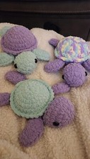 3 crochet turtles of varying colors.