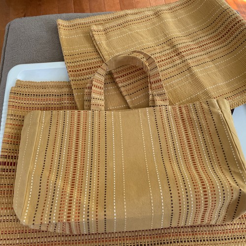 MCM~ORO CON TAPETES DE LUGAR TEJIDOS A RAYAS, CORREDOR DE MESA Y SERVILLETAS CON BOLSO DE MANO A JUEGO