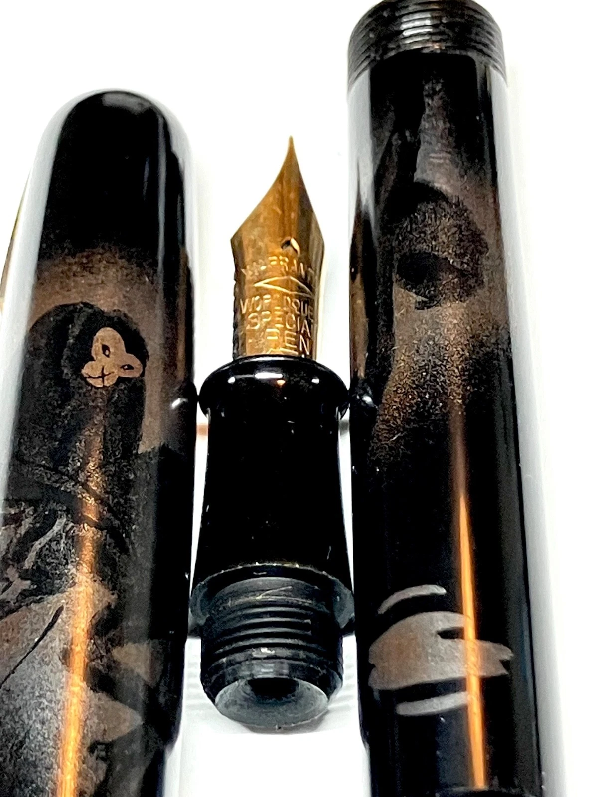 Black vintage fountain pen with gold nib, “HARUYAMA made urushi maki-e” text, and gold ink blotter on wooden surface.