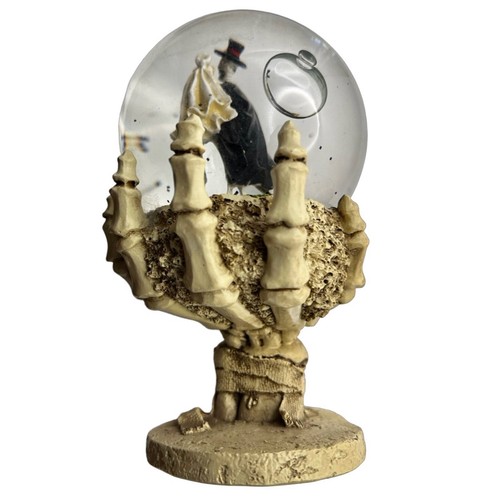 Skeleton Bride and Groom On Grave Snow Globe In Palm Of Skeleton Hand - Picture 2 of 5