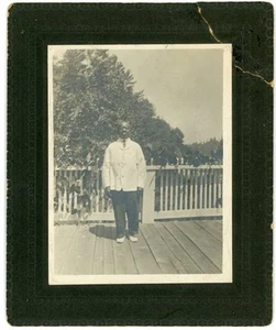 Foto - Schwarzer Mann mit weißer Jacke posiert auf Deck - um 1910 - Bild 1 von 3