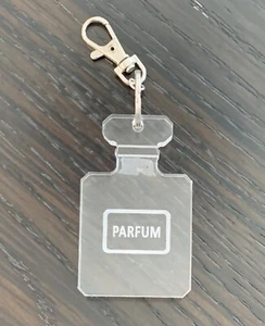 CADENA LLAVERO LLAVERO BOTELLA PERFUME ACRÍLICO TRANSPARENTE, HERRAJES PLATEADOS, 5" DE LARGO - Imagen 1 de 2