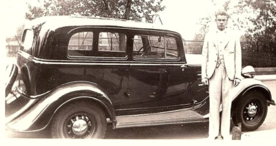 Foto de coche de automóvil real de la década de 1940 modelo clásico temprano hombre posando en blanco y negro Foto 1 de 4