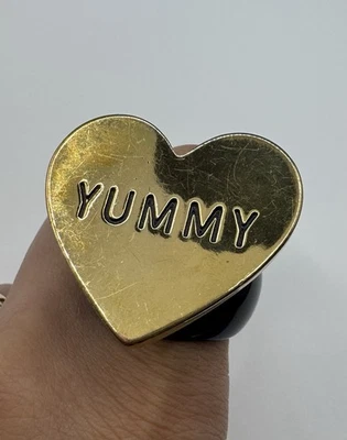 Anillo Betsey Johnson Grueso Corazón Distintivo “DELICIOSO” Tono Dorado y Negro Talla 7 Foto 1 de 4