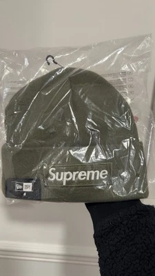 🫒 GORRO SUPREME NEW ERA LOGO CAJA FW25 Oliva - EN MANO 🫒  Foto 1 de 3