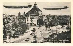 GERMAN PHOTO POSTCARD: HINDENBURG GRAF ZEPPELIN OVER BUSY STREET - Picture 1 of 2