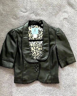 Chaqueta de cuero negra Marciano. Talla pequeña. Cierre de botones recortados de manga corta Foto 1 de 4