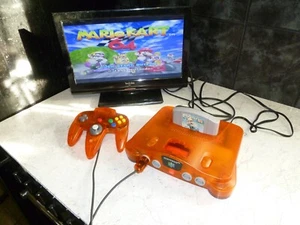 CONSOLE NINTENDO 64 ARANCIONE CON MARIO KART 64 PERFETTAMENTE FUNZIONANTE LEGGI ALTRO - Foto 1 di 12