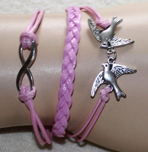 Armband im Infinity-Style in Rosa, mit verschiedenen Anhängern