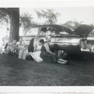 Fotografía instantánea vintage sentada al lado del coche con el maletero abierto - Imagen 1 de 6