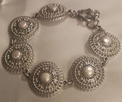Un hermoso brazalete brazalete de joyería con dije de perlas de imitación en tono plateado y de moda Foto 1 de 4