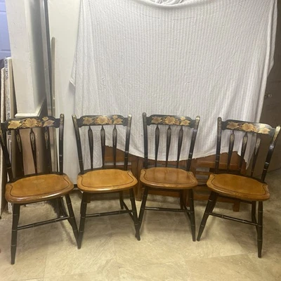 Juego de cuatro bonitas sillas Hitchcock antiguas estampadas negras y doradas, fondo de madera. Foto 1 de 4