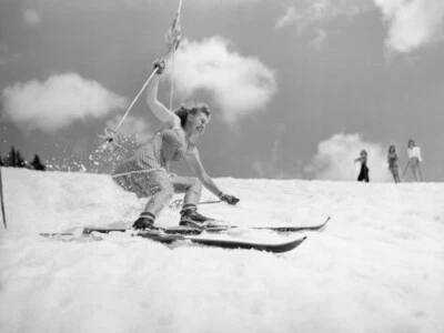 Foto de póster de esquí slalom de niña vintage, mujer joven primavera esquí en falda, 1940 Foto 1 de 2