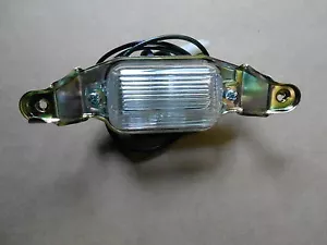 66 67 68 69 70 71 72 73 El Camino License Plate Light Lens Assembly NEW - Foto 1 di 1